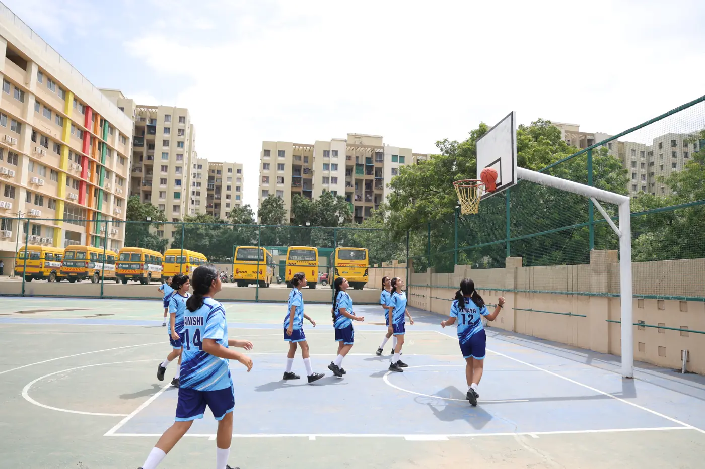 Students practising basketball on the outdoor court