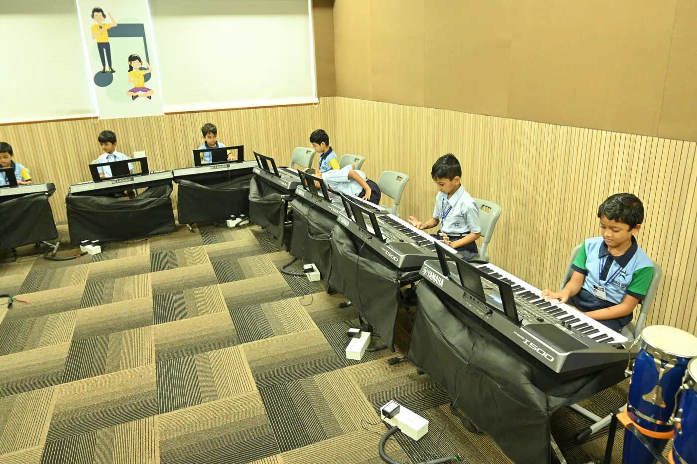 Young students playing keyboards in the music room
